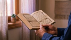 Open Quran resting on hands with soft morning light coming through a window